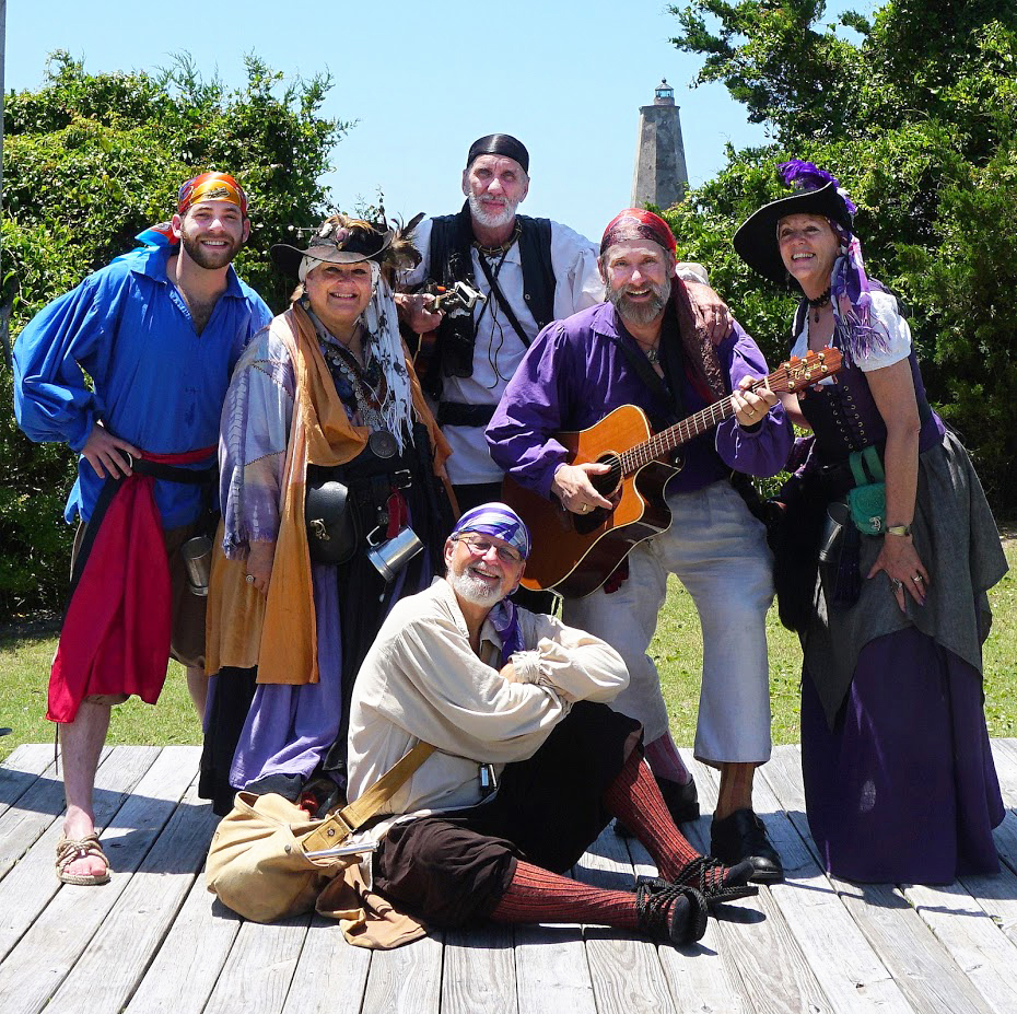 group of people wearing pirate attire and holding guitar