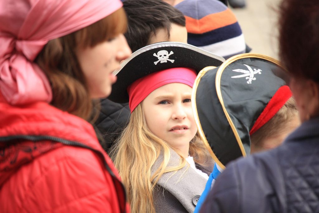 little girl looking at camera, group of kids wearing pirate hats