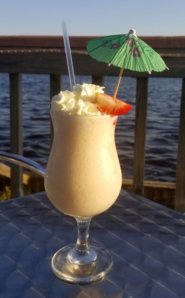 daiquiri with umbrella on patio overlooking the river